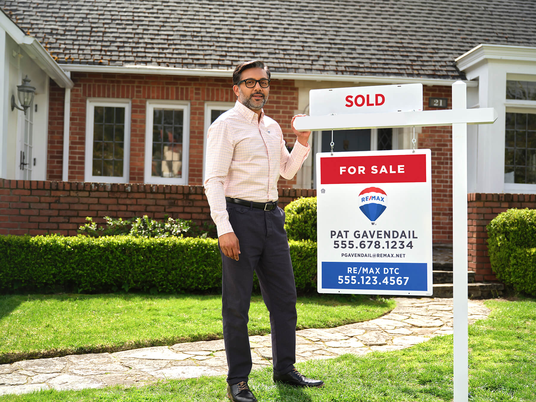 Exteriors_Fuji_3482_RD2 RE/MAX agent with a yard sign sign in front of a home